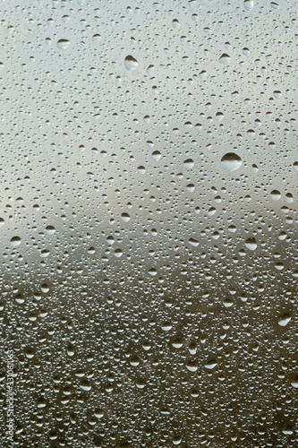 Rain drops on window glasses surface with cloudy background . Natural Pattern of raindrops isolated on cloudy background.