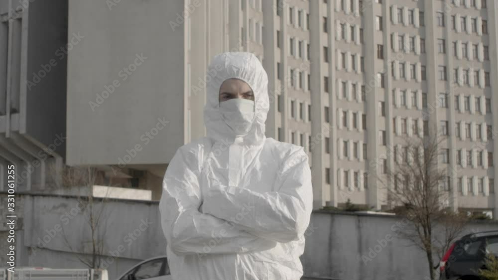 Portrait of serious male scientist in protective suit standing in front of big research laboratory center building in urban daytime city during pandemic coronavirus quarantine time 4K Portrait of serious male scientist in protective suit standing in front of big research laboratory center building in urban daytime city during pandemic coronavirus quarantine time 4K