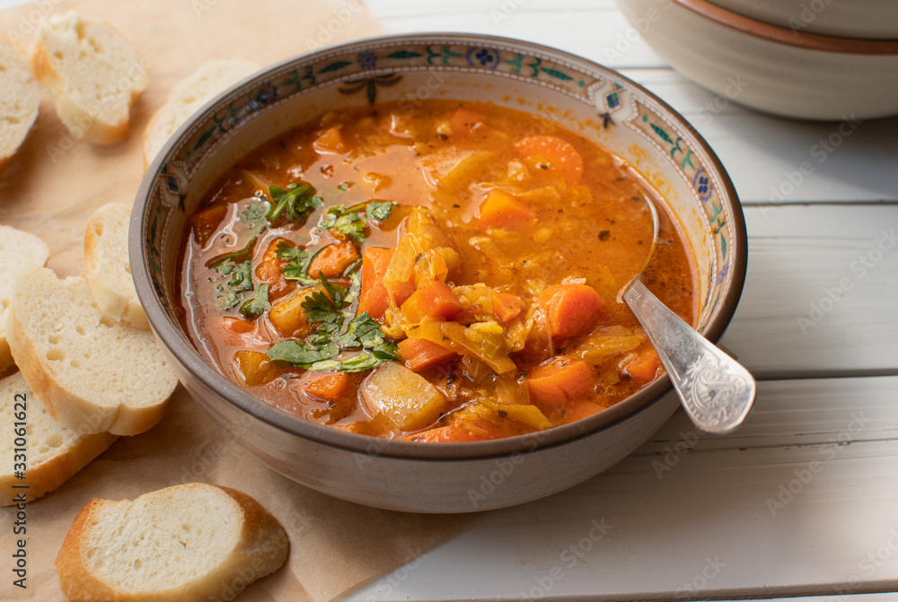Vegan lentil and vegetables  soup bowl on wooden table
