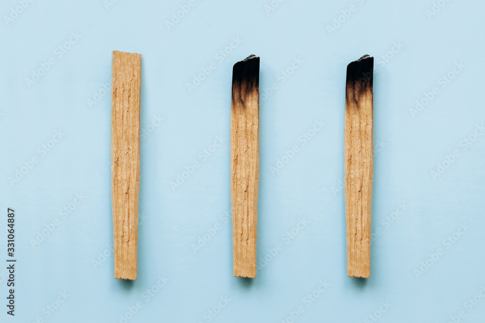 Palo Santo sticks on a blue background. They are used in aromatherapy and religious rites and meditations. Palo Santo sticks on a blue background. They are used in aromatherapy and religious rites and meditations.