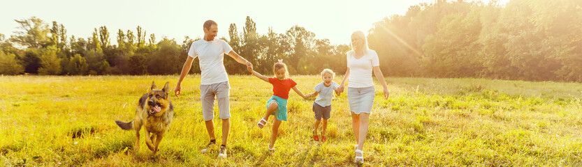 family, pet, domestic animal and people concept - close up of family with German Shepherd on walk in park