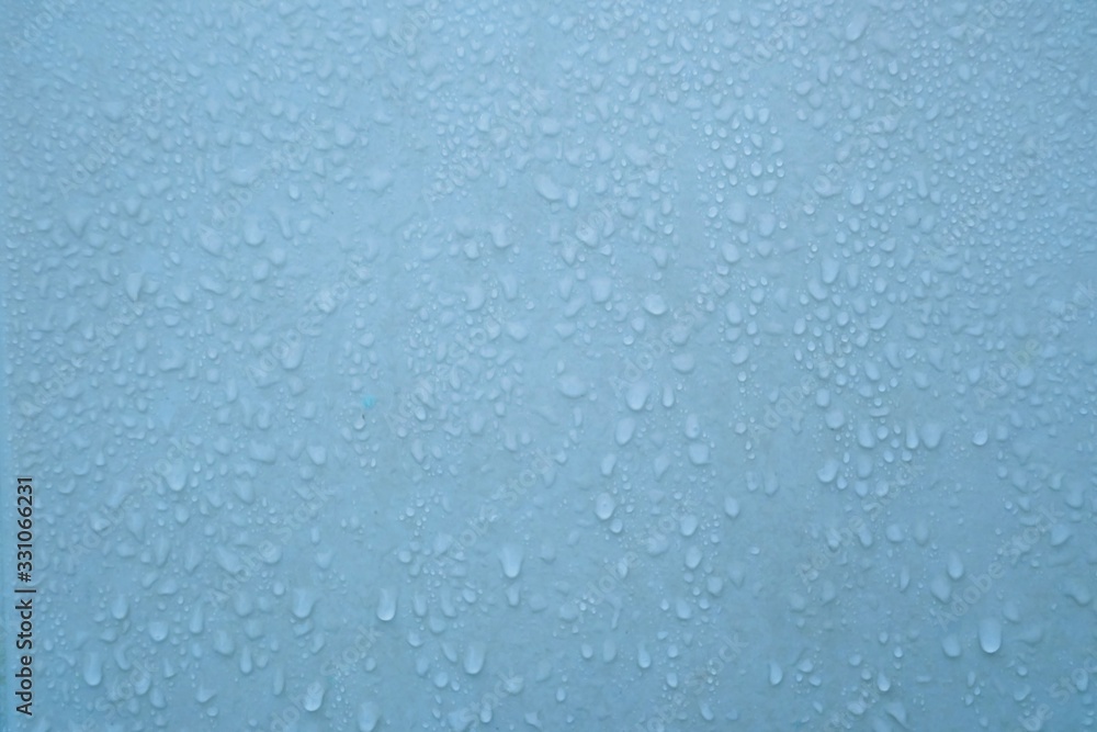 In selective focus many droplets on blue wall with wet pattern for backdrop texture