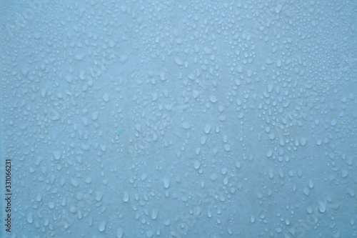 In selective focus many droplets on blue wall with wet pattern for backdrop texture