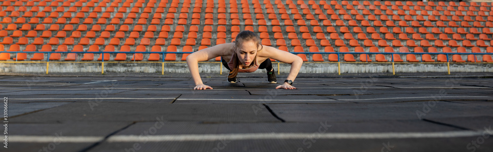 Fototapeta premium Female athlete preparing legs for cardio workout. Fitness runner doing warm-up routine. woman runner warm up outdoor. athlete stretching and warming up on a running track in a stadium