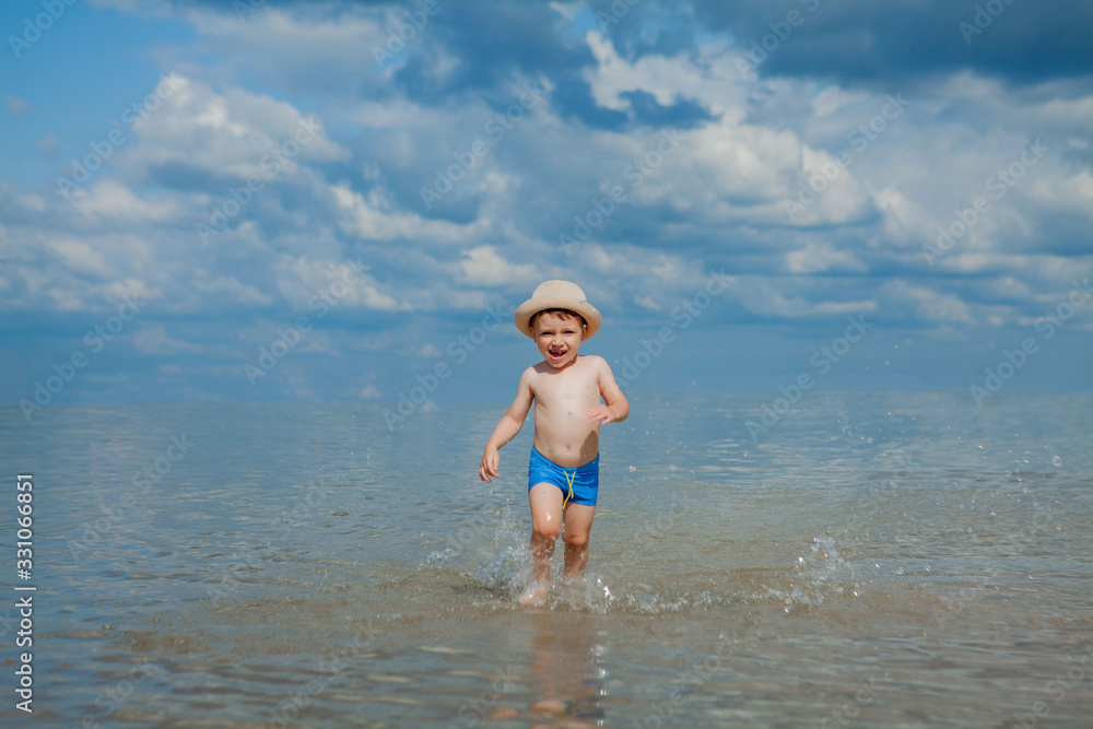 Fototapeta premium cute child running from sea waves on beach