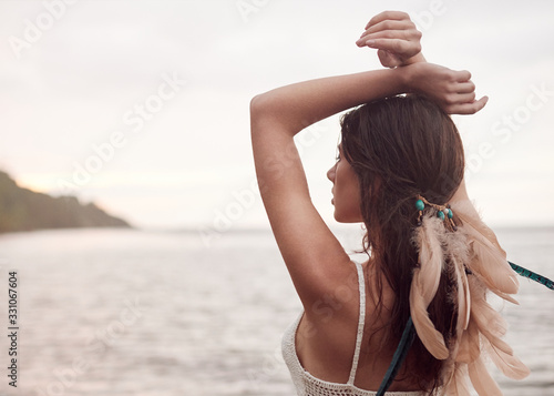 girl in an Indian headdress, portrait by the sea at sunset, naturlane light, boho style