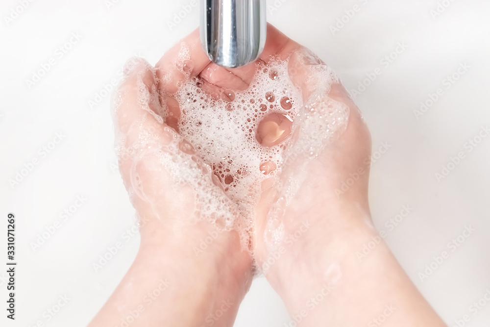 Fototapeta premium Washing hands with soap under the faucet with water
