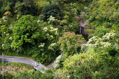 Car Drives along One Lane Road in Jungle with Waterfall