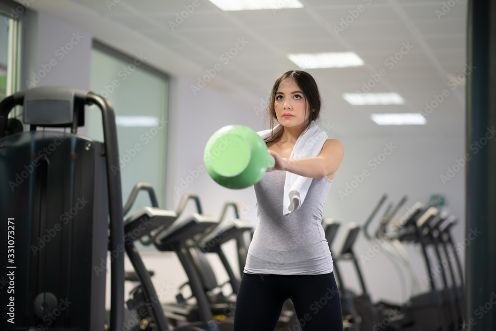 Woman training in a gym using a kettlebell Woman training in a gym using a kettlebell