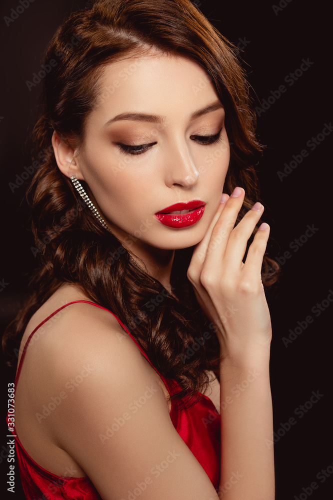 Side view of attractive brunette woman with red lips and hand near face isolated on black Side view of attractive brunette woman with red lips and hand near face isolated on black