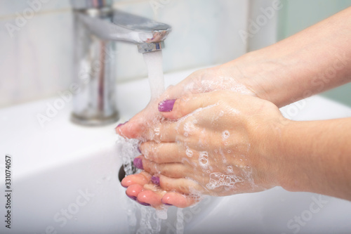 Girl washes hands with soap in the bathroom. Virus Prevention. Coronavirus protection.