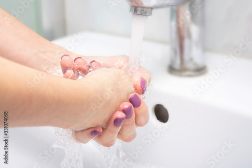 Woman washes hands with soap in the bathroom. Coronavirus protection. Virus Prevention.