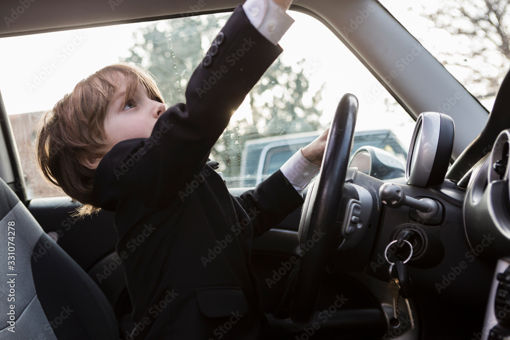 6 year old boy sitting in car holding steering wheel 6 year old boy sitting in car holding steering wheel