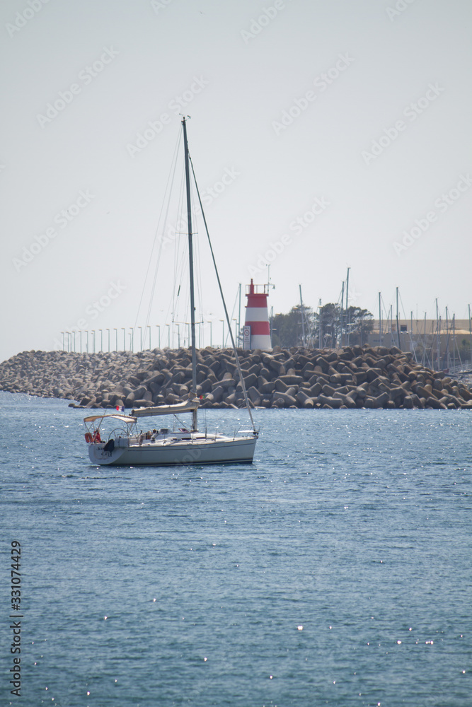 Boat in front of lighthouse in Portugal