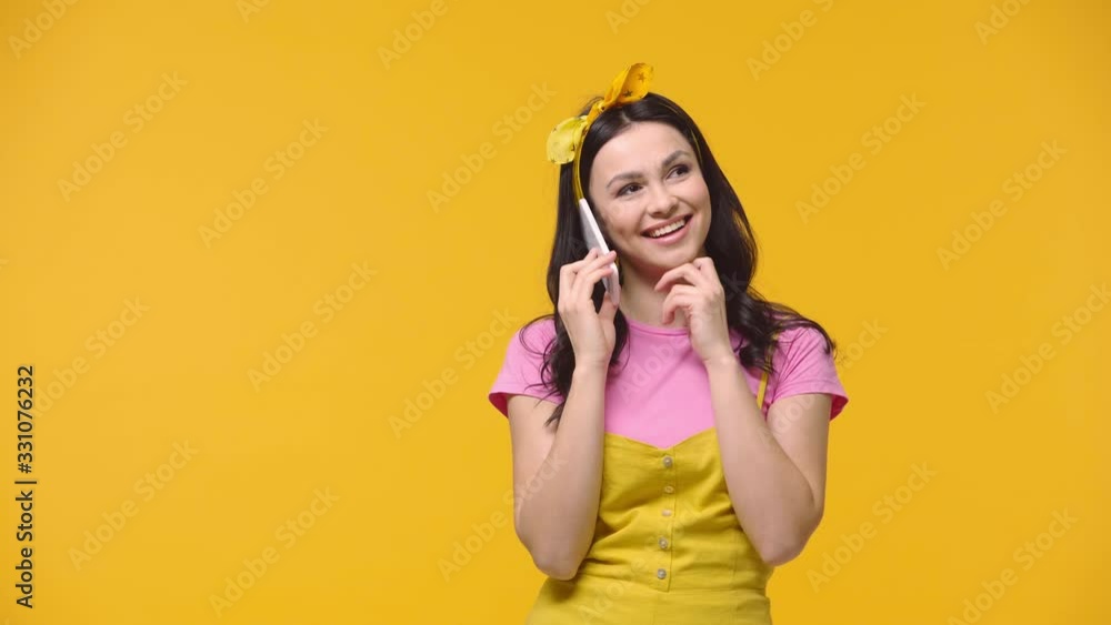 Woman talking on smartphone isolated on yellow Woman talking on smartphone isolated on yellow