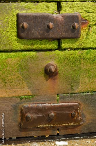 Rusted metal plates on a wooden groyne © Vic