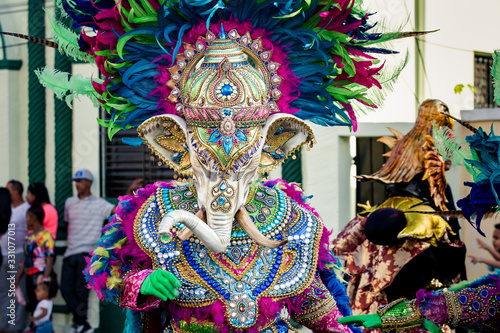 human in vivid elephant costume poses for photo on city street at dominican carnival