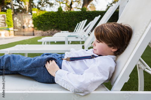 6 year old boy reclining on lawn chair photo