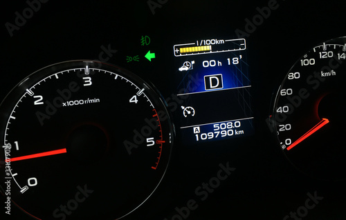 Diesel car tachometer and speedometer dashboard illumination at night. Fossil fuel cars economy problem