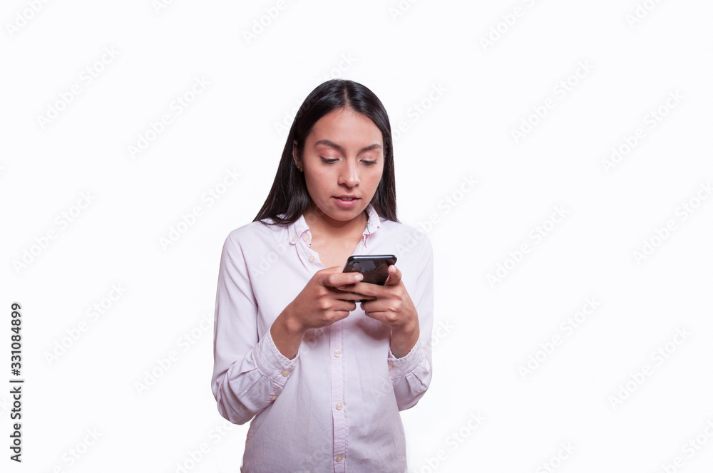 young latin girl smiling and talking on the cell phone on white background dressed in pink young latin girl smiling and talking on the cell phone on white background dressed in pink