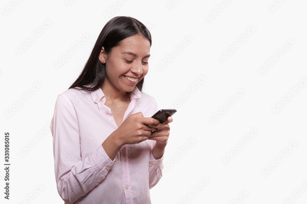 young latin girl smiling and talking on the cell phone on white background dressed in pink young latin girl smiling and talking on the cell phone on white background dressed in pink