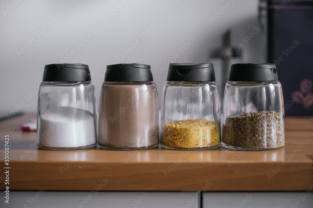 Seasonings like salt, pepper and spices on a wooden table. Seasonings like salt, pepper and spices on a wooden table.