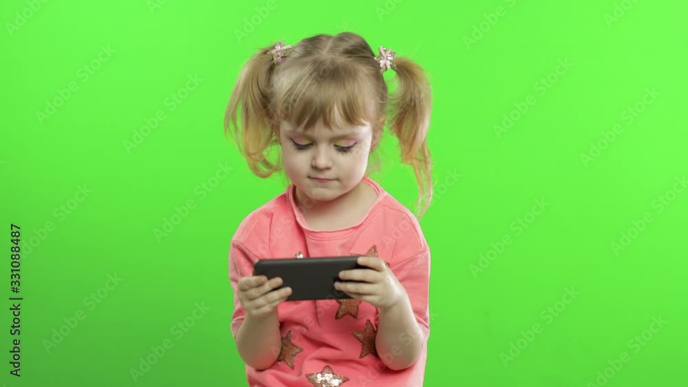Little girl using smartphone. Portrait of child with smartphone texting, playing Little girl using smartphone. Portrait of child with smartphone texting, playing