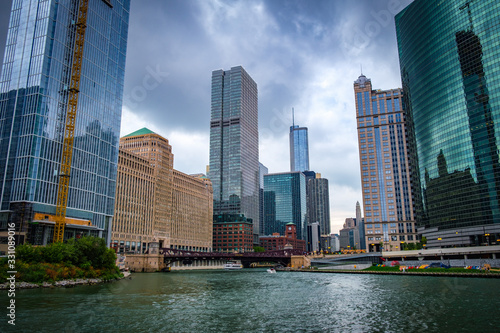 Low angle view of Chicago skyscrapers along the Chicago river against cloudy sky. 