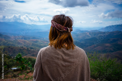 Chica hippie mirando la inmensidad de las montañas