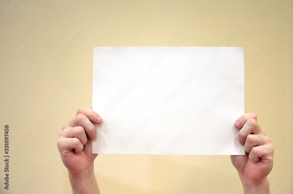 Man holds white and blank paper on yellow background. Man holds white and blank paper on yellow background.