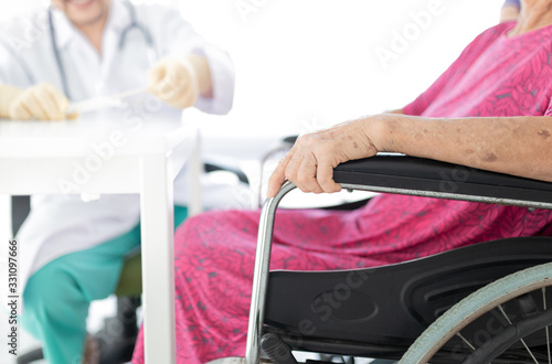 close up hand, old asian patient sitting on wheelchair, she talk about her symptoms with doctor in hospital, elderly healthcare promotion