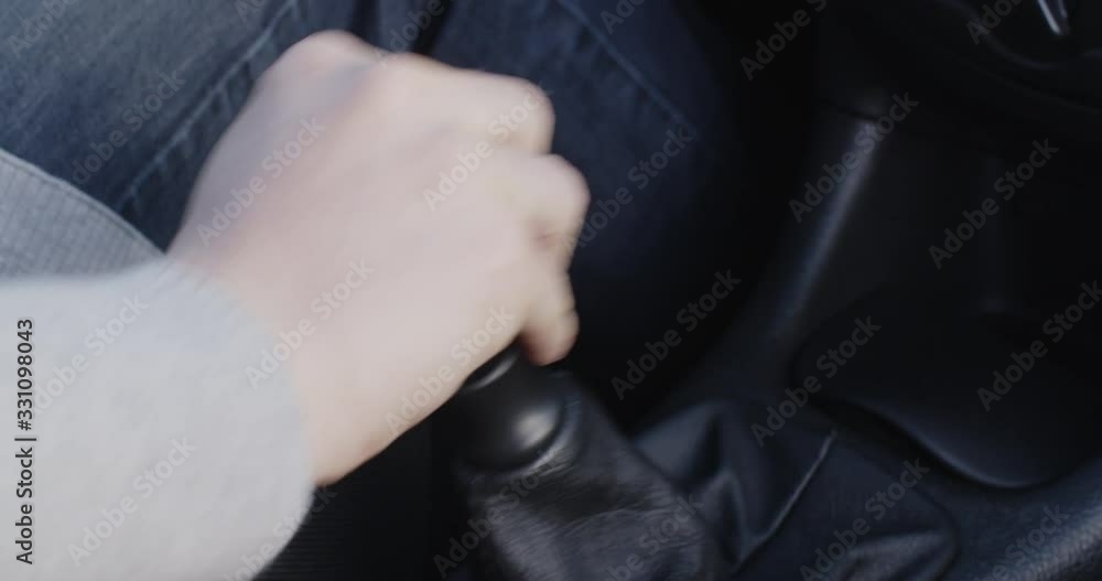 Woman driving a car and manually changing gears. Closeup handheld shot. Woman driving a car and manually changing gears. Closeup handheld shot.