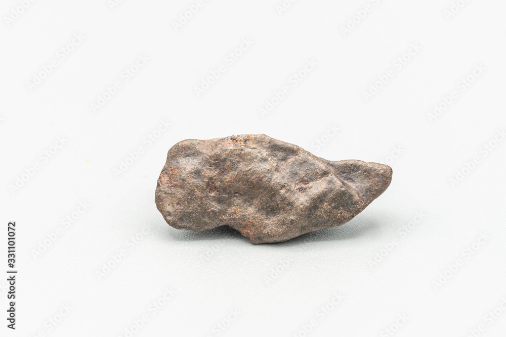 Fototapeta premium Chondrite Meteorite L6W2 Type isolated, piece of rock formed as an asteroid in the universe at during Solar System creation. The meteorite comes from an asteroid fall impacting Earth at Atacama Desert