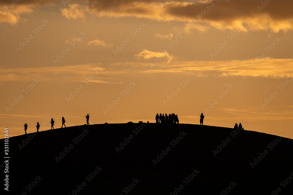 People on Sand Dune at Sunrise, Sahara Desert, Morocco People on Sand Dune at Sunrise, Sahara Desert, Morocco