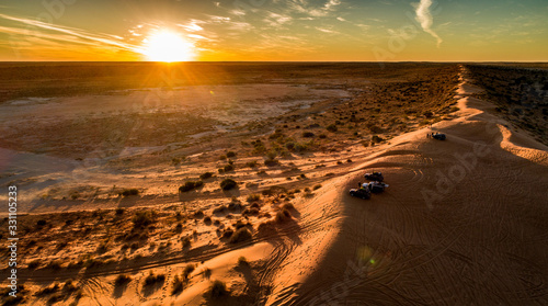 Outback travellers in their 4WD's enjoy sunset drinks atop Big Red sand dune west of Birdsville. photo