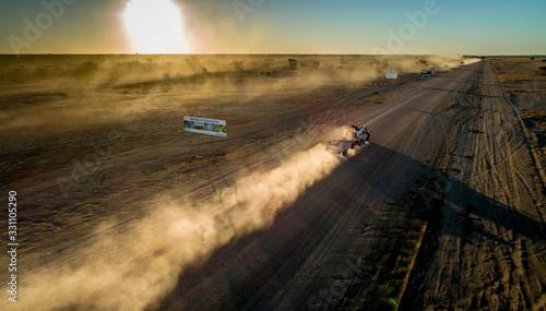 Four wheel drives cross the SA/QLD border at sunset on the Birdsville Track photo