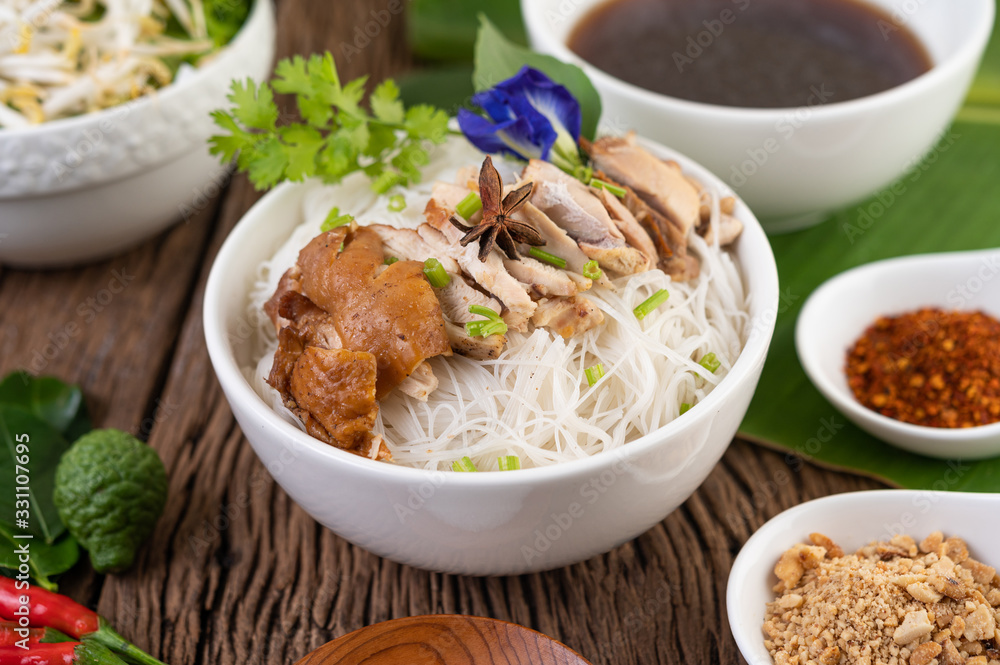 Chicken noodle in a bowl with side dishes, Thai food Chicken noodle in a bowl with side dishes, Thai food