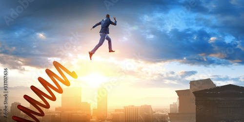 Businessman jumping on springboard . Mixed media