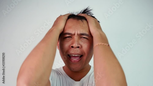 Close up portrait of bored Asian man covering face like facepalm expressing frustration or shame over grey background. Emotion and expression concepts.