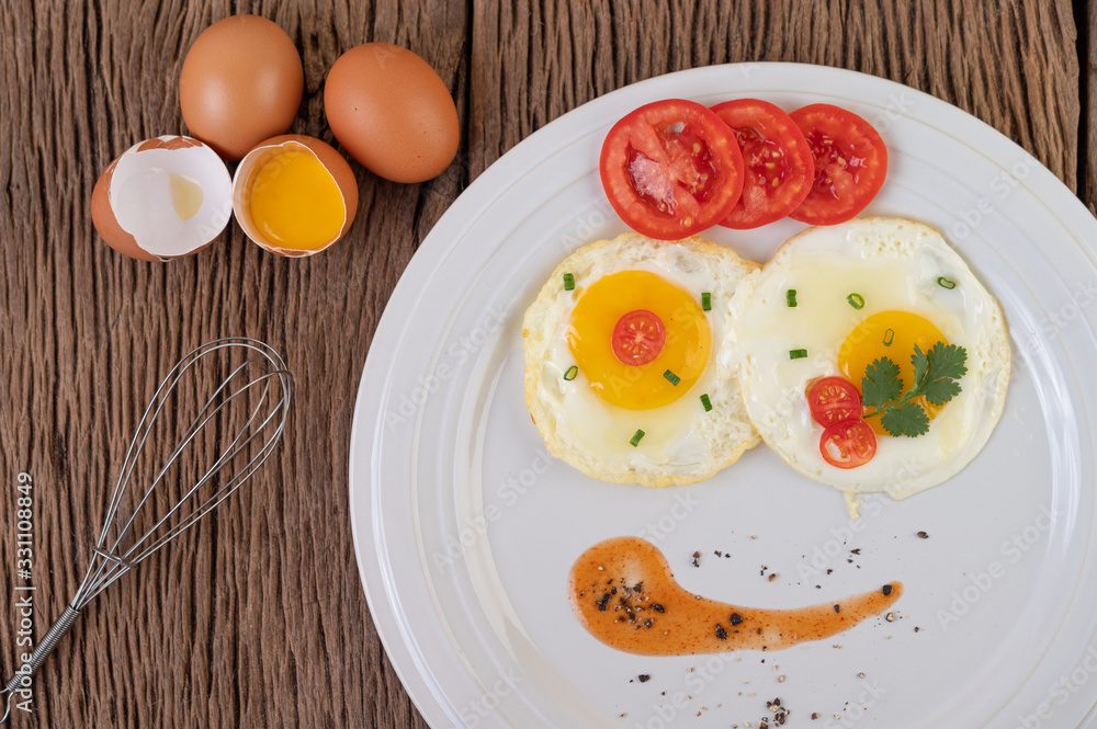 Fried egg on a white plate with sliced Spring onion and sliced tomatoes Fried egg on a white plate with sliced Spring onion and sliced tomatoes