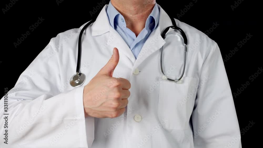 Close up doctor hand in medical gown showing thumb up. Practitioner in medical coat with stethoscope showing thumbs up isolated on black background Close up doctor hand in medical gown showing thumb up. Practitioner in medical coat with stethoscope showing thumbs up isolated on black background