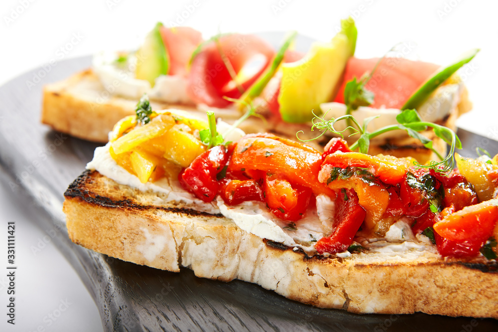 Tasty bruschetta with fish and baked peppers