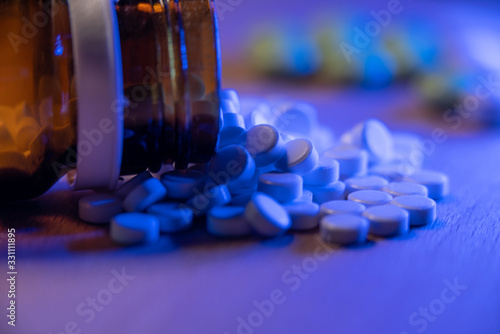 Small pills and tablets with a glass bottle filled with medicine. Viral infection medication and drugs