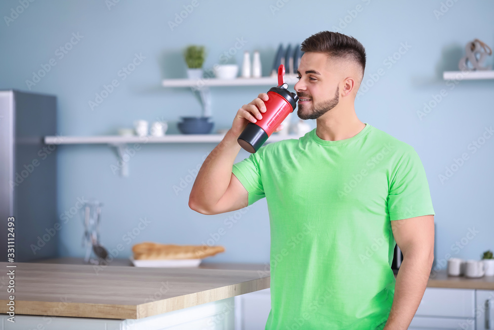 Sporty man with protein shake in kitchen Sporty man with protein shake in kitchen
