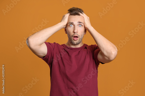 Shocked man on color backgr...