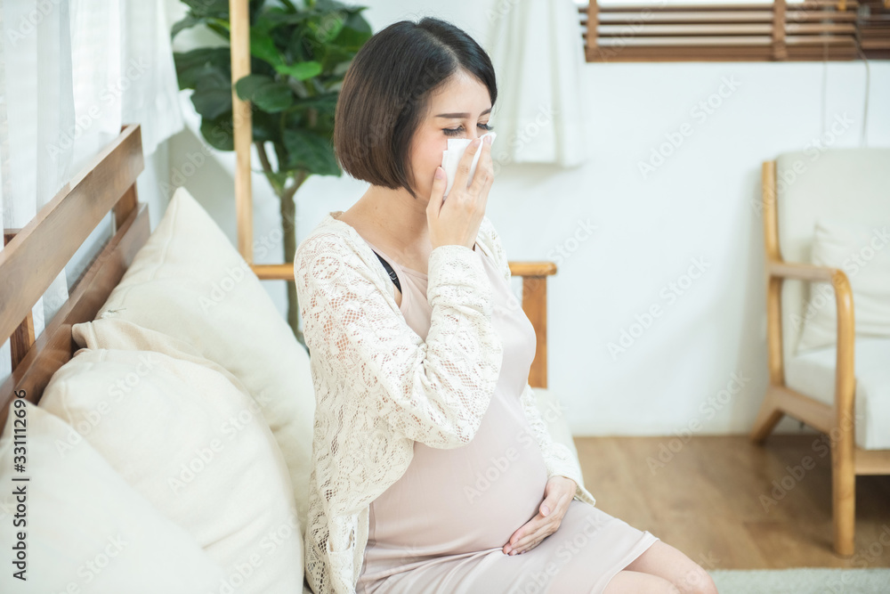 pregnant asian female use tissue paper close mouth and nose, she cough and feeling fever, pregnancy and people concept - sick pregnant woman blowing nose with paper tissue at home pregnant asian female use tissue paper close mouth and nose, she cough and feeling fever, pregnancy and people concept - sick pregnant woman blowing nose with paper tissue at home