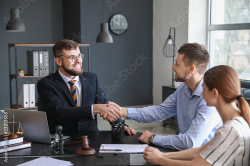 Male lawyer with client shaking hands in office photo