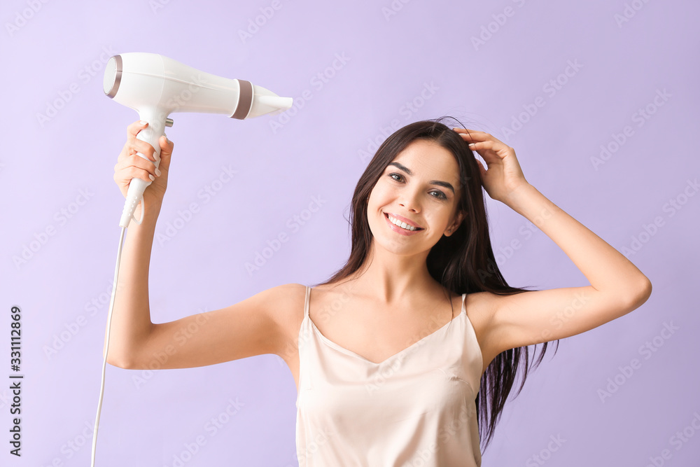 Beautiful young woman with hair dryer on color background Beautiful young woman with hair dryer on color background
