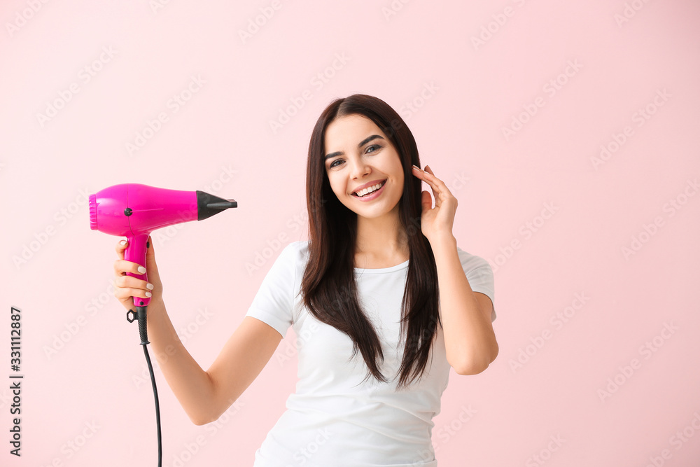 Beautiful young woman with hair dryer on color background Beautiful young woman with hair dryer on color background