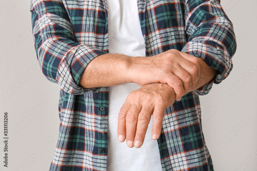 Senior man suffering from Parkinson syndrome on grey background, closeup Senior man suffering from Parkinson syndrome on grey background, closeup